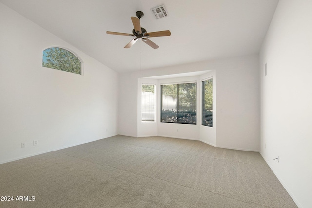 unfurnished room featuring ceiling fan, light colored carpet, and lofted ceiling