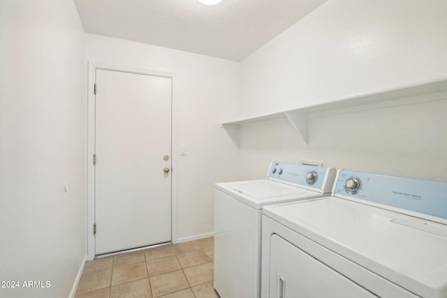 washroom with washer and clothes dryer and light tile patterned floors