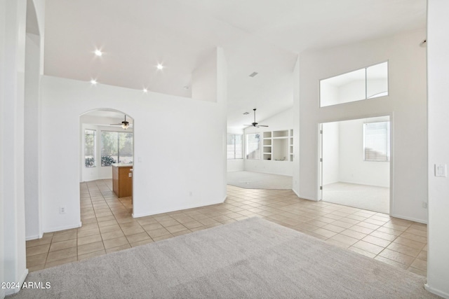 carpeted spare room with high vaulted ceiling