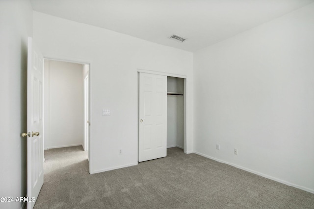 unfurnished bedroom with carpet flooring and a closet