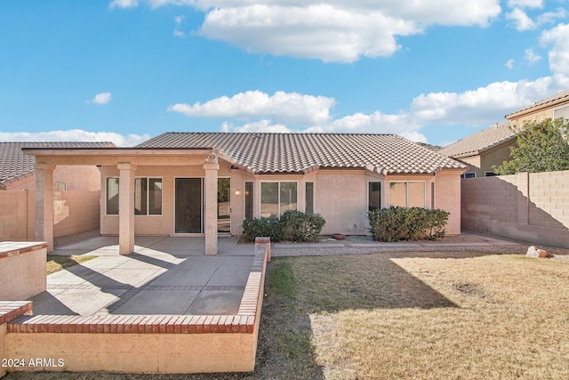 rear view of property featuring a patio area and a yard