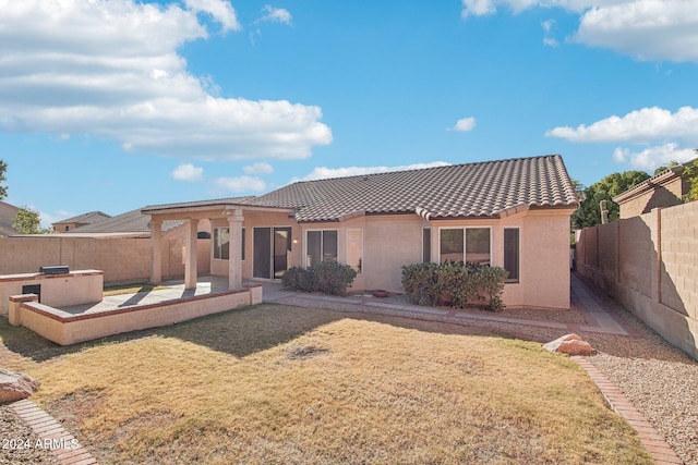 back of house with a lawn and a patio area