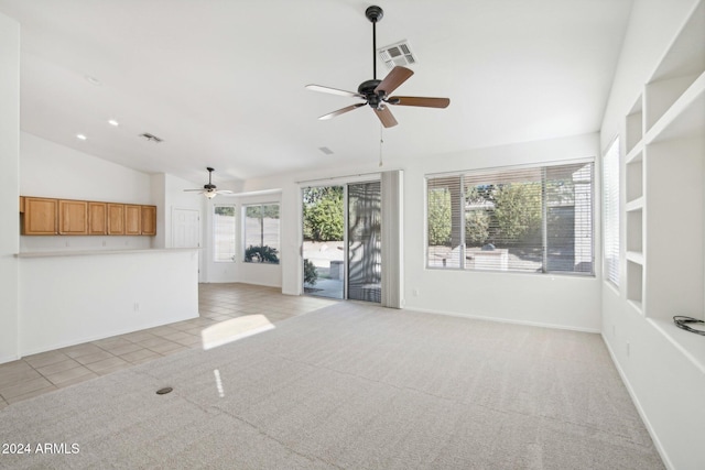 unfurnished living room featuring ceiling fan, light tile patterned floors, a healthy amount of sunlight, and vaulted ceiling