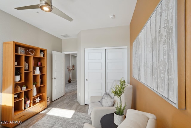 sitting room featuring light wood-type flooring and ceiling fan