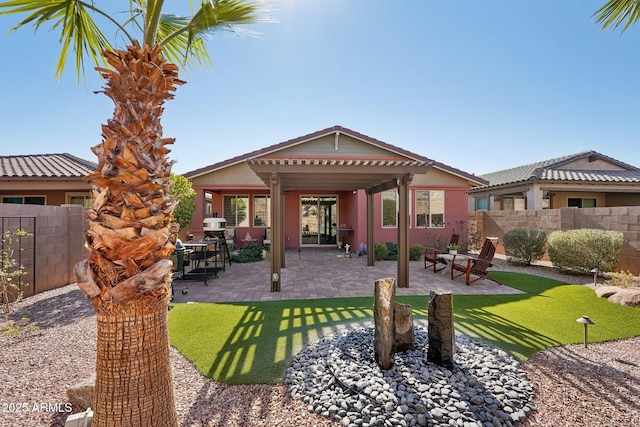 rear view of property featuring a patio area and a yard