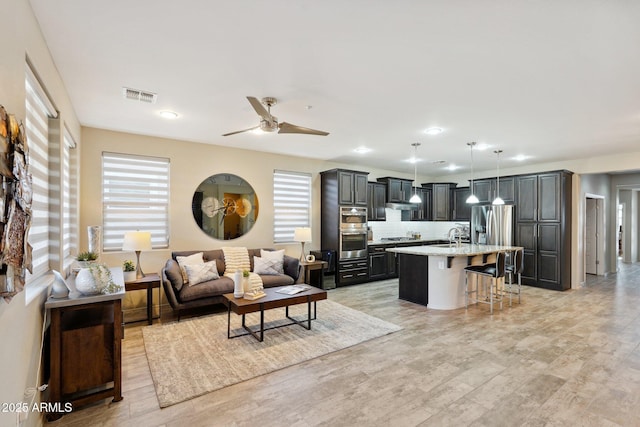 living room featuring ceiling fan and light hardwood / wood-style floors