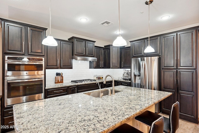 kitchen with decorative light fixtures, decorative backsplash, sink, and stainless steel appliances