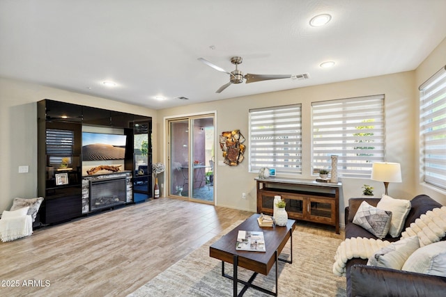 living room featuring ceiling fan and light hardwood / wood-style flooring