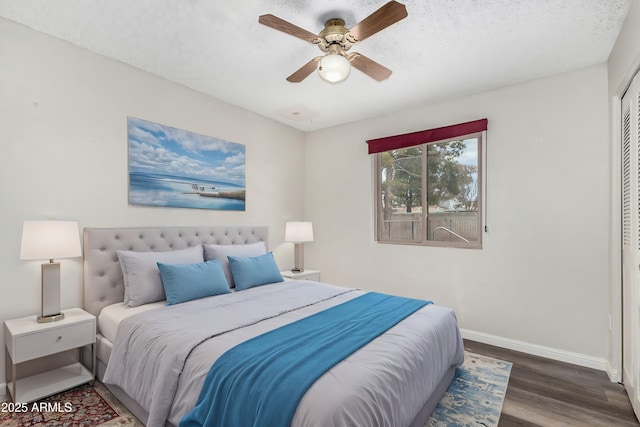 bedroom featuring a closet, dark hardwood / wood-style floors, a textured ceiling, and ceiling fan