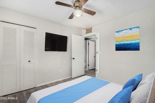 bedroom featuring a closet, dark hardwood / wood-style floors, and ceiling fan