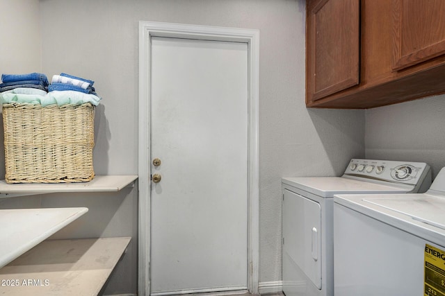 clothes washing area with cabinets and washer and dryer