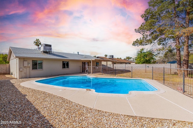 pool at dusk featuring central AC