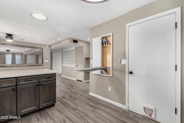 kitchen with ceiling fan, dark brown cabinetry, and light hardwood / wood-style floors