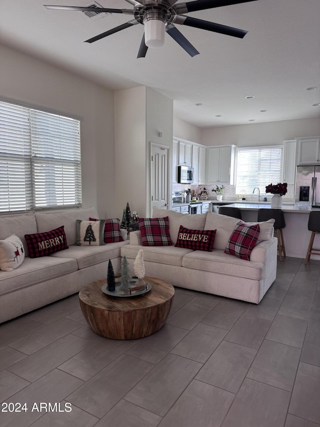 living room with ceiling fan and sink