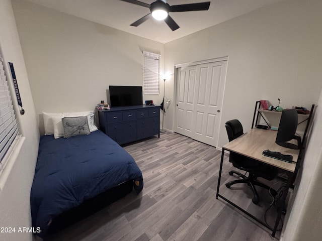 bedroom with ceiling fan, light hardwood / wood-style floors, and a closet