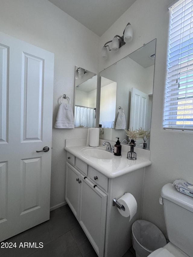 bathroom with tile patterned flooring, vanity, and toilet