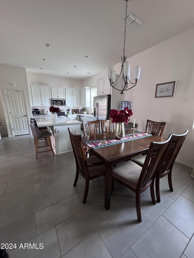 tiled dining space featuring a chandelier