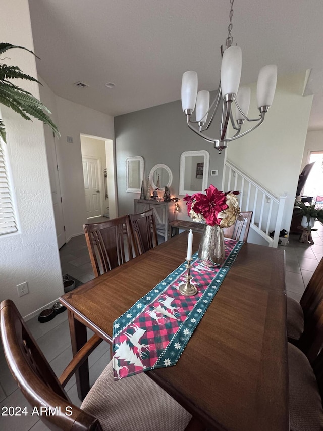 tiled dining space with a chandelier