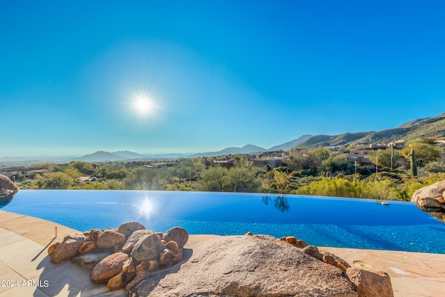 view of swimming pool with a mountain view