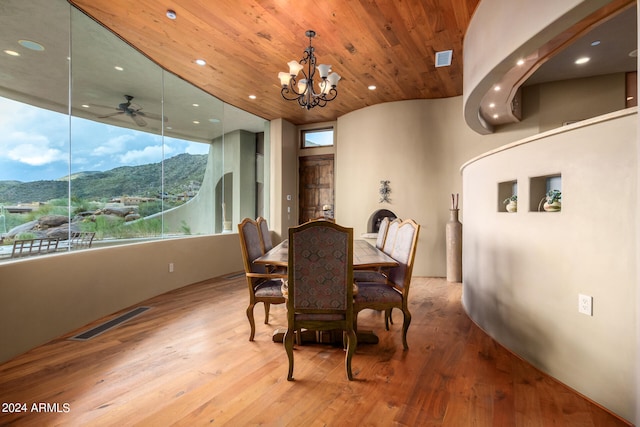 dining room with ceiling fan with notable chandelier, a mountain view, light hardwood / wood-style floors, and plenty of natural light