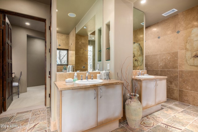 bathroom featuring double sink, tile floors, large vanity, and tile walls