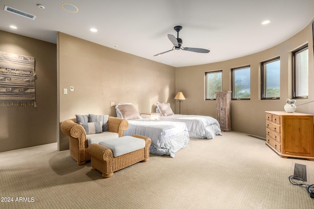 bedroom featuring multiple windows, light colored carpet, and ceiling fan