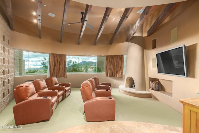 living room with a high ceiling, carpet, ceiling fan, and beamed ceiling