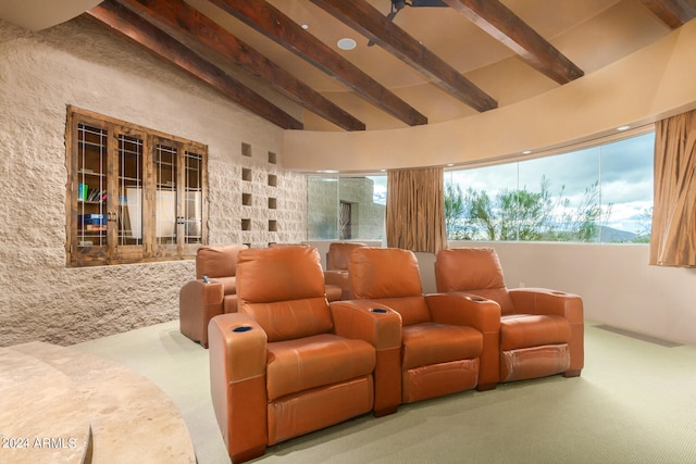 carpeted home theater featuring beam ceiling and high vaulted ceiling