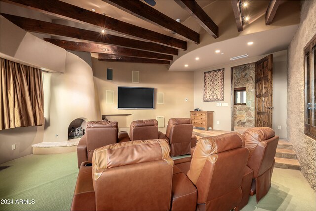 carpeted cinema featuring beam ceiling