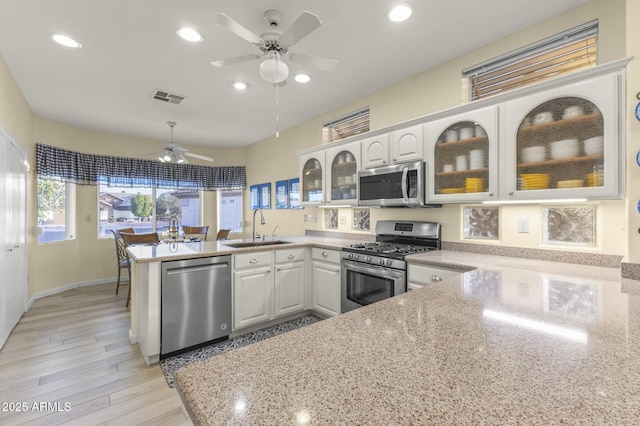 kitchen featuring white cabinetry, appliances with stainless steel finishes, sink, and kitchen peninsula