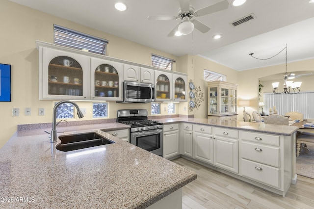 kitchen with white cabinetry, appliances with stainless steel finishes, kitchen peninsula, and sink