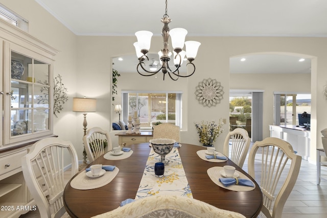 dining room featuring ornamental molding, wood-type flooring, and an inviting chandelier