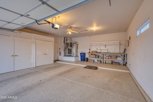 garage featuring a garage door opener, heating unit, and gas water heater