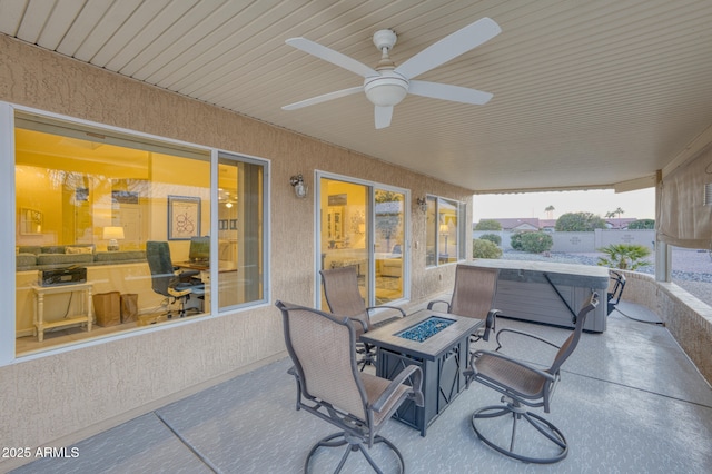 view of patio / terrace featuring a hot tub, ceiling fan, and an outdoor fire pit