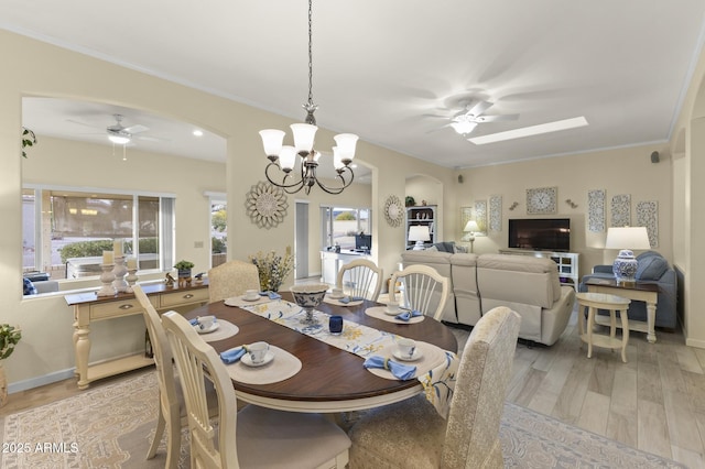 dining space with ceiling fan with notable chandelier, crown molding, and light hardwood / wood-style floors