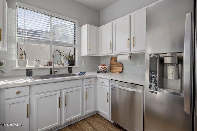 kitchen with decorative backsplash, sink, white cabinets, and appliances with stainless steel finishes