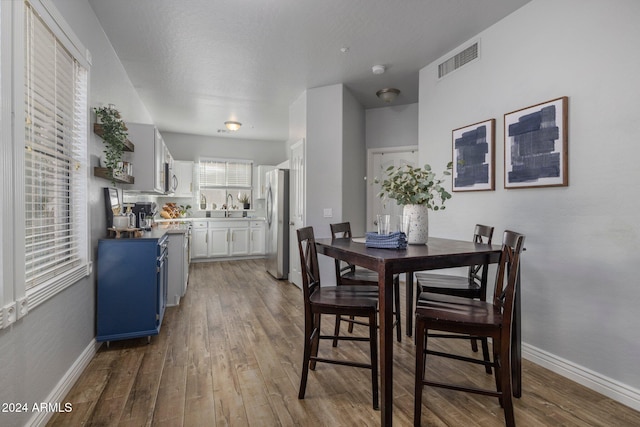 dining area with wood-type flooring and sink