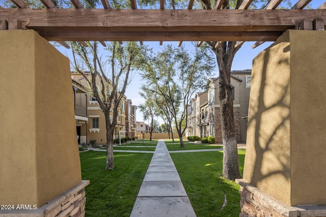 surrounding community featuring a lawn and a pergola