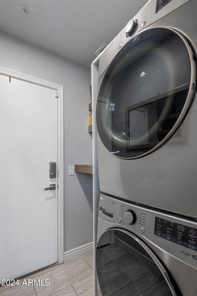 laundry room featuring stacked washer / drying machine