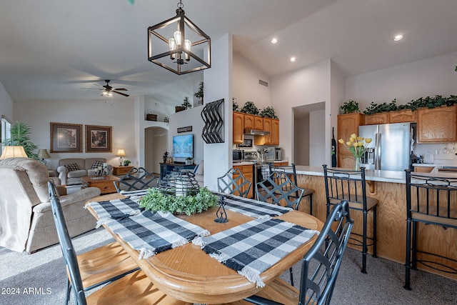 dining space with ceiling fan with notable chandelier and high vaulted ceiling