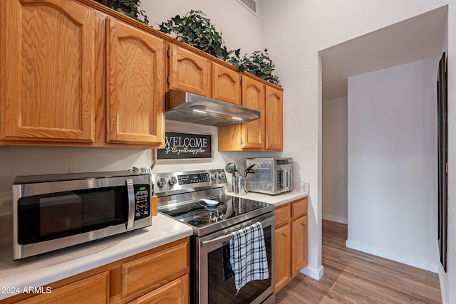 kitchen featuring light wood-type flooring and appliances with stainless steel finishes