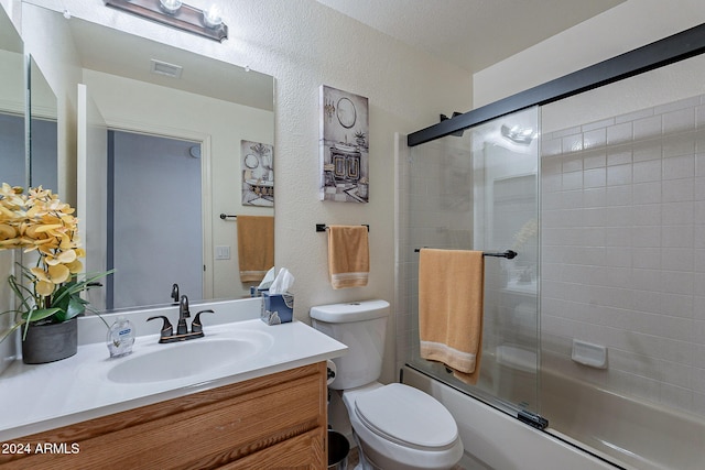 full bathroom with vanity, toilet, and shower / bath combination with glass door