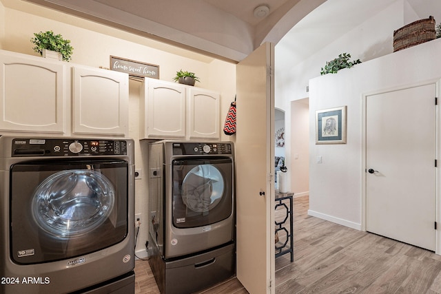 laundry area featuring cabinets, light wood-type flooring, and independent washer and dryer