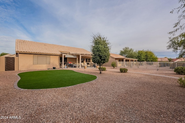 rear view of property featuring a lawn and a patio area