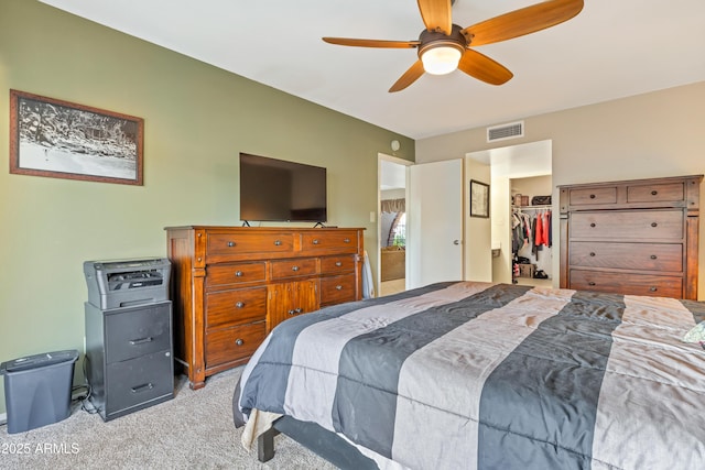 bedroom featuring ceiling fan, light colored carpet, a spacious closet, and a closet