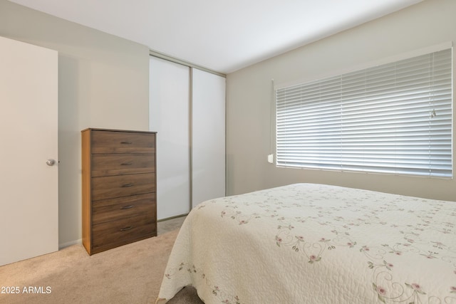 bedroom featuring light colored carpet and a closet