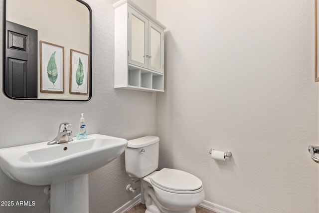 bathroom with toilet and baseboards