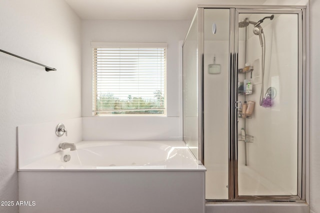 bathroom with a stall shower and a garden tub