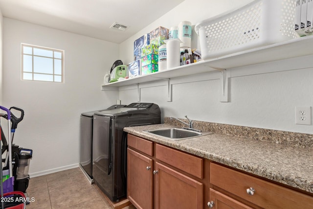 washroom with light tile patterned floors, laundry area, a sink, visible vents, and independent washer and dryer