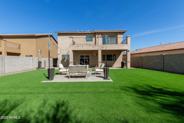 back of house with a fenced backyard, a balcony, an outdoor hangout area, a lawn, and stucco siding